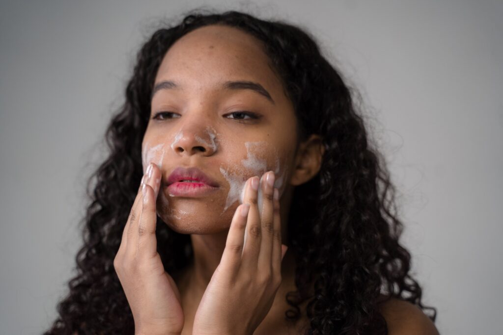 girl washing face with facial foam, doing her facial cleansing routine