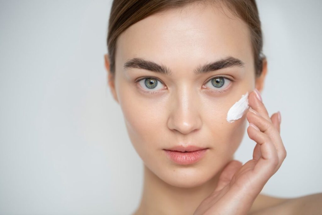 portrait-beautiful-woman-with-clear-skin-using-moisturizer-her-face